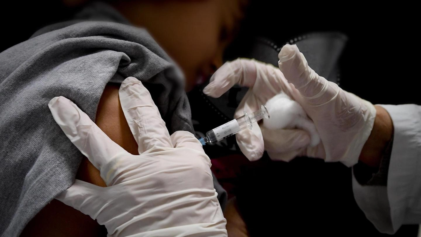 Un bambino viene vaccinato in un ambulatorio (Ansa)