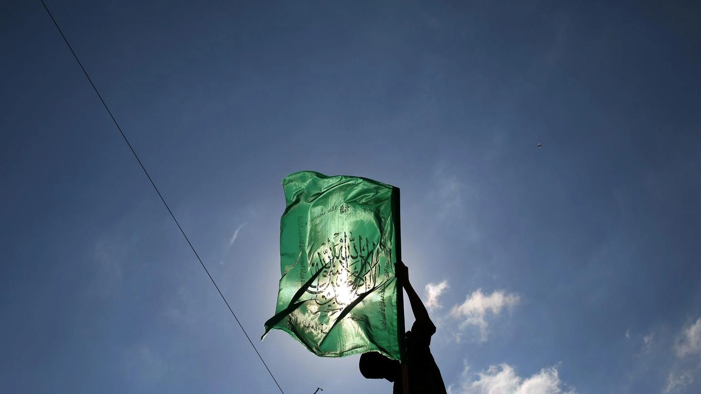 Un militante con la bandiera di Hamas (Ansa)