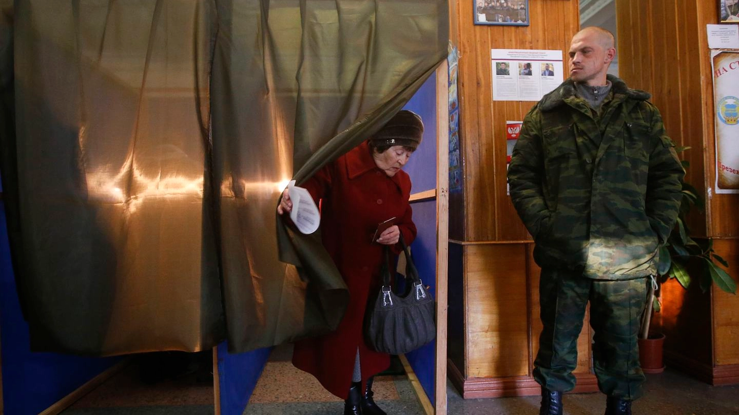 Un'anziana esce dalla cabina elettorale in un seggio di Donetsk (Reuters)