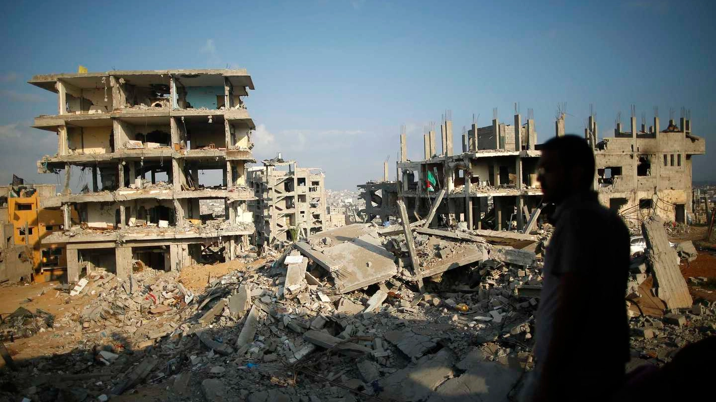 Un palestinese guarda la devastazione provocata a Gaza dai raid israeliani (Reuters)