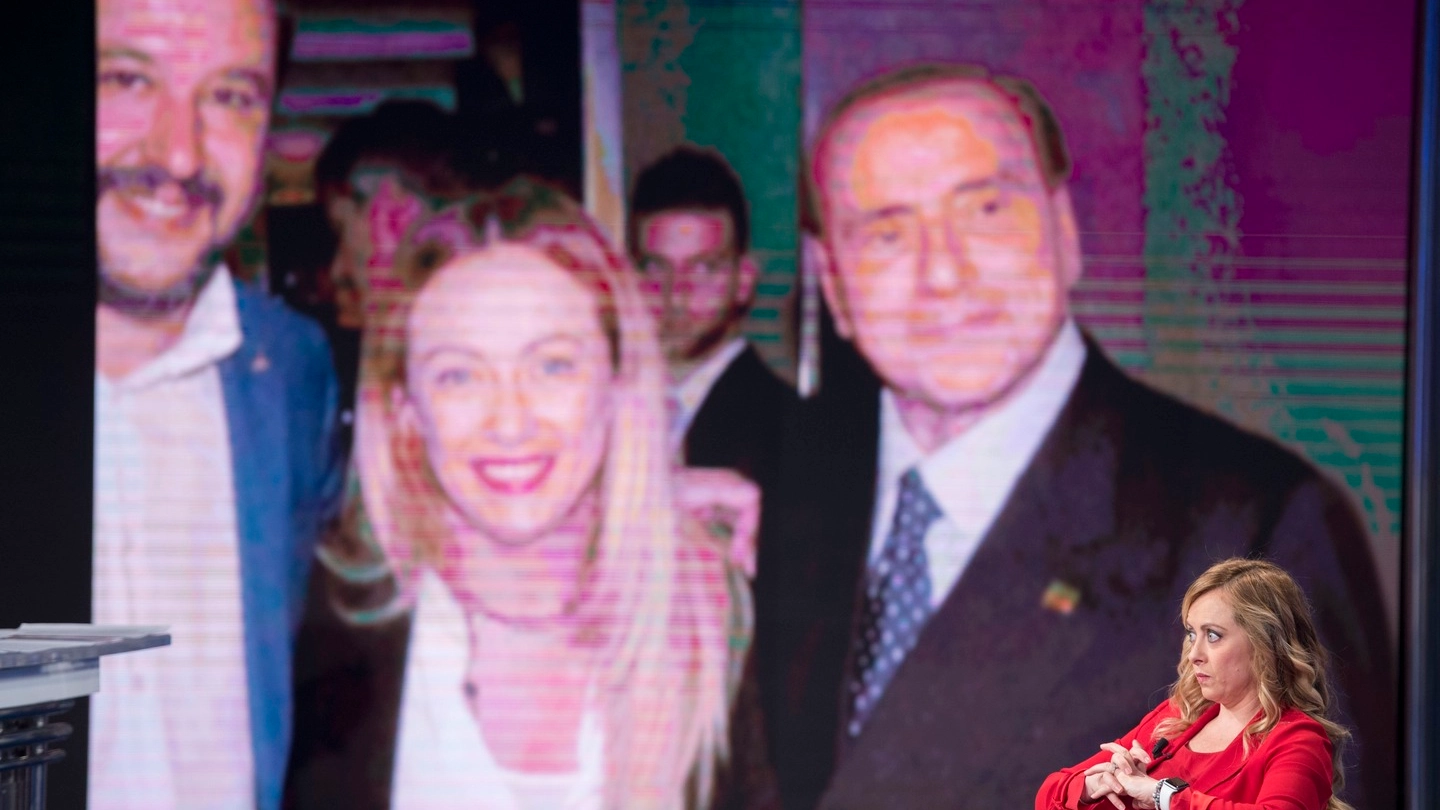Giorgia Meloni e sullo sfondo Berlusconi e Salvini (ImagoE)
