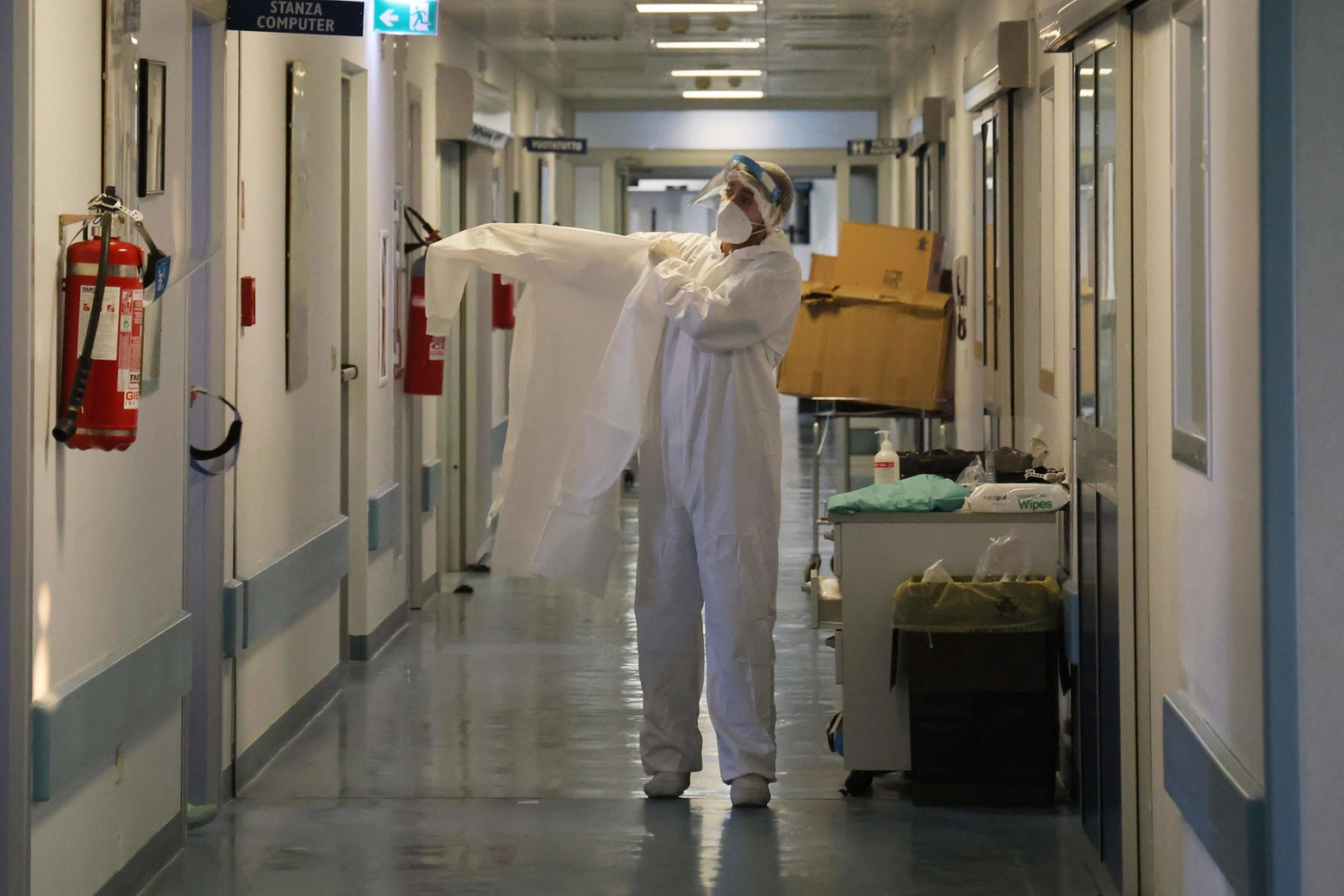Operatore sanitario indossa tuta e mascherina protettive al lavoro in terapia intensiva