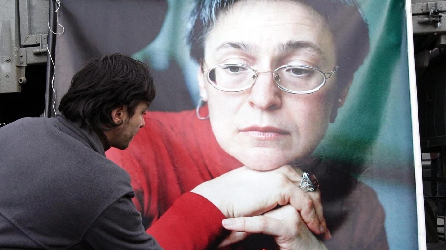 Un uomo russo porge un fiore sulla tomba della giornalista Anna Politkovskaya (Ansa)