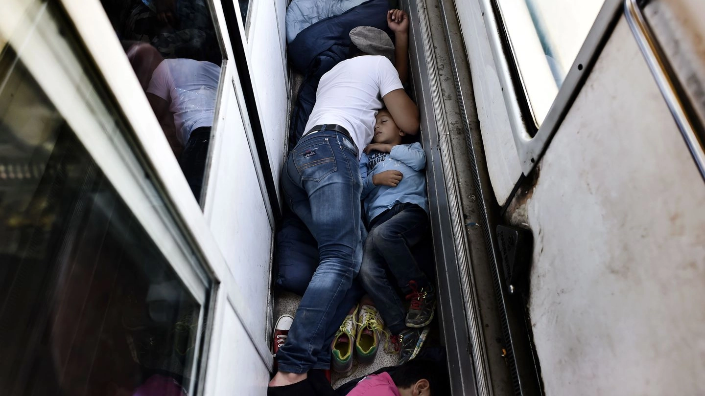 Migranti attraversano in treno il confine tra Macedonia e Serbia (Afp)