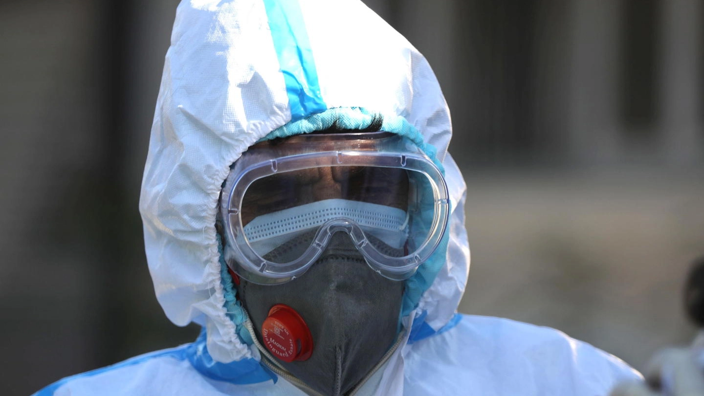 Un operatore sanitario indossa le protezioni anti Coronavirus (Ansa)