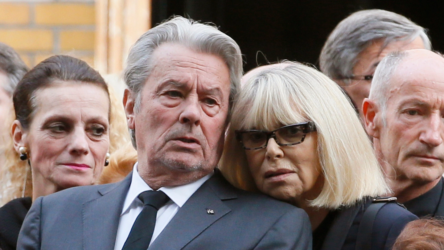 Alain Delon e l'attrice Mireille Darc al funerale del regista e attore Pierre Mondy