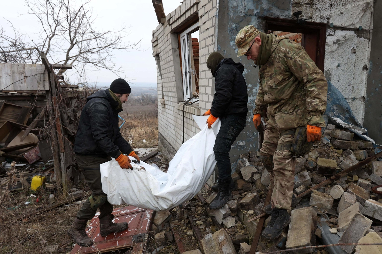 Volontari ucraini spostano il corpo di un soldato russo nel Donetsk, 18 gennaio 2023 (Afp)
