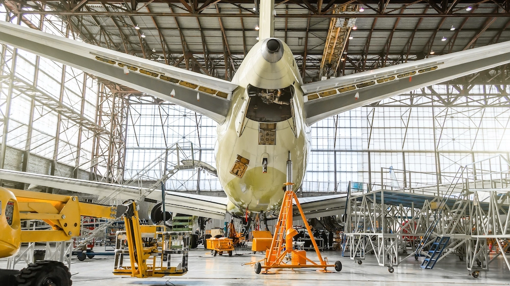 Passenger aircraft on service in an aviation hangar rear view of the tail, on the auxiliary power unit.