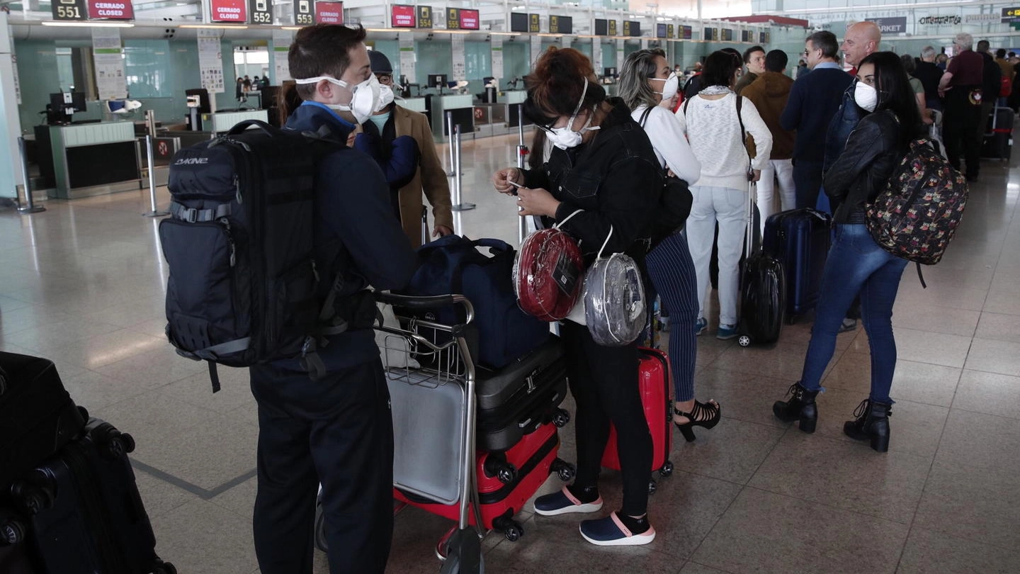 Viaggitori in attesa di imbarcarsi in aeroporto (Ansa)