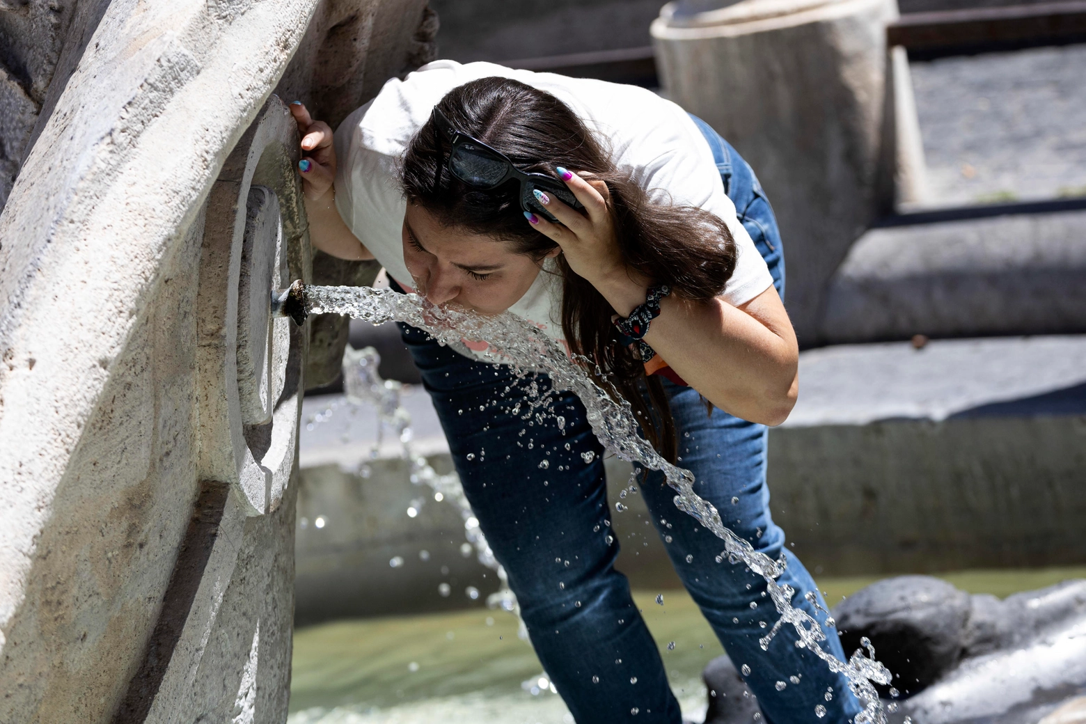 Prima ondata di caldo del 2023. Una ragazza beve in una fontana a Roma (Ansa)