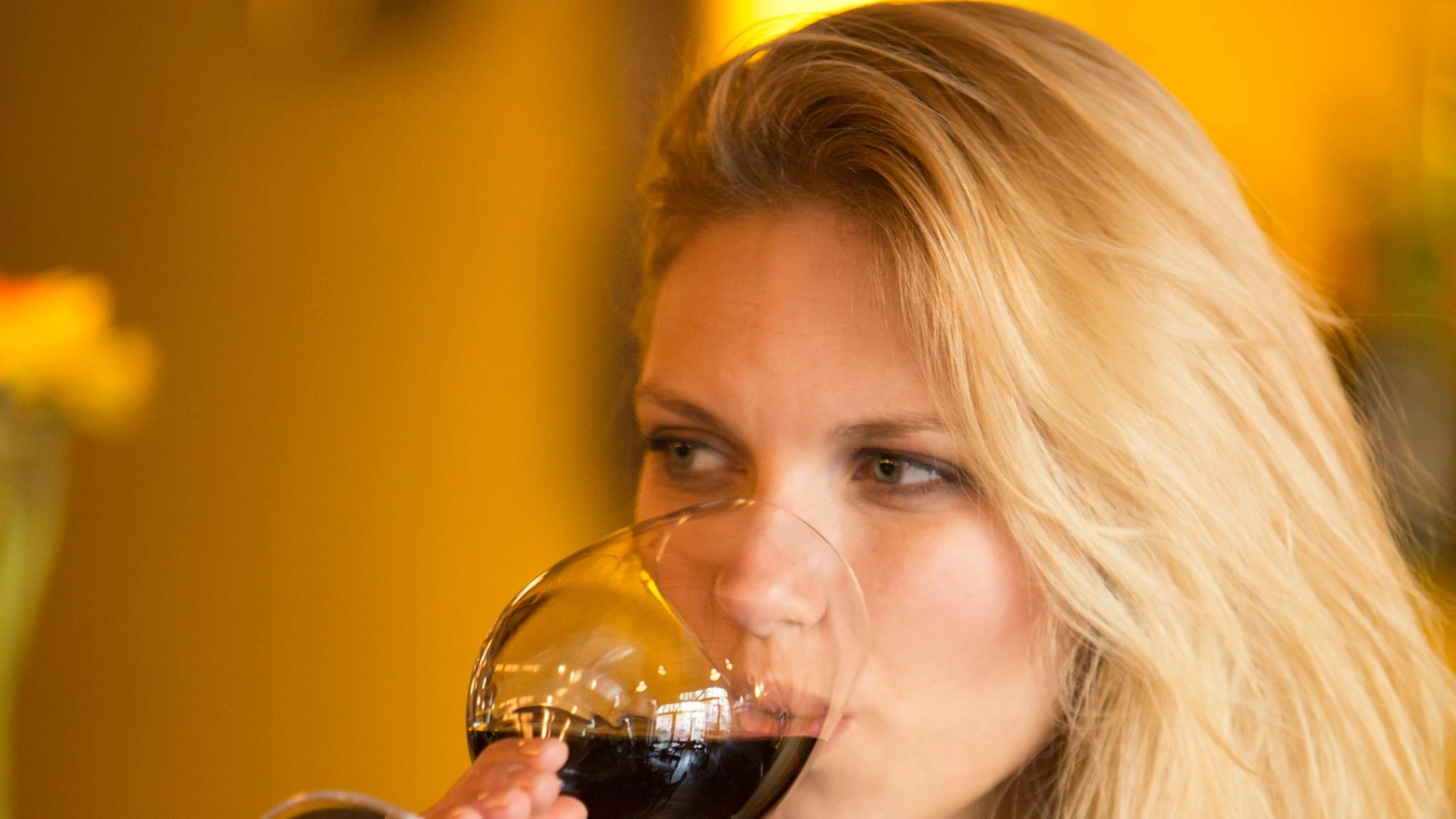 Una ragazza beve un bicchiere di vino