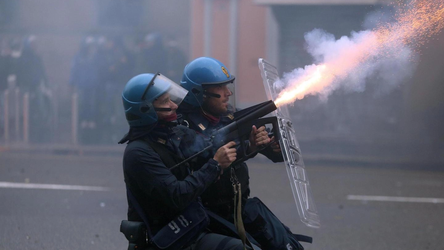 DISORDINI Due agenti della polizia durante le devastazione dei No Expo a Milano. Undici feriti tra le forze dell’ordine (Ansa)