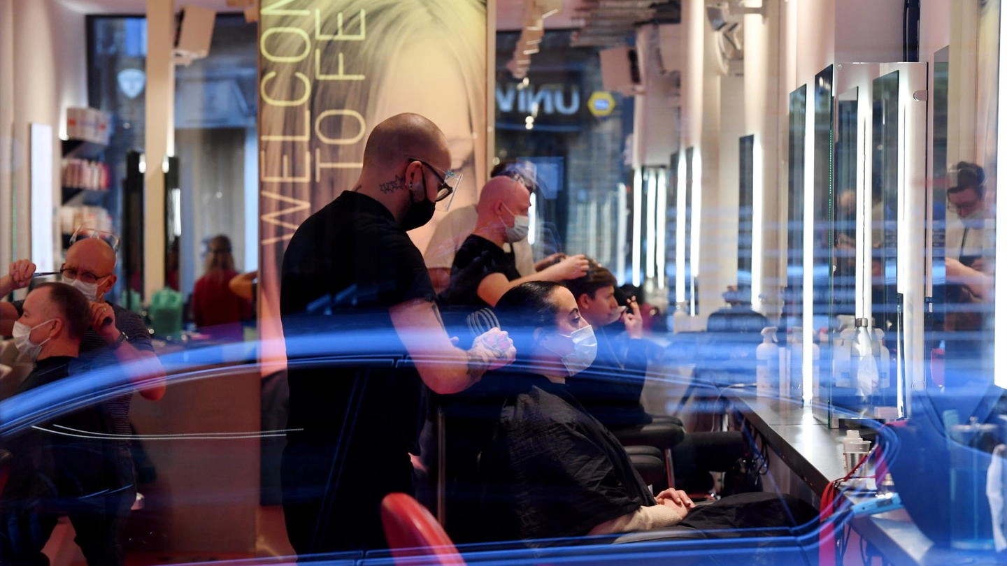 Londra, alcuni clienti in un salone di parrucchieri a Soho (Ansa)