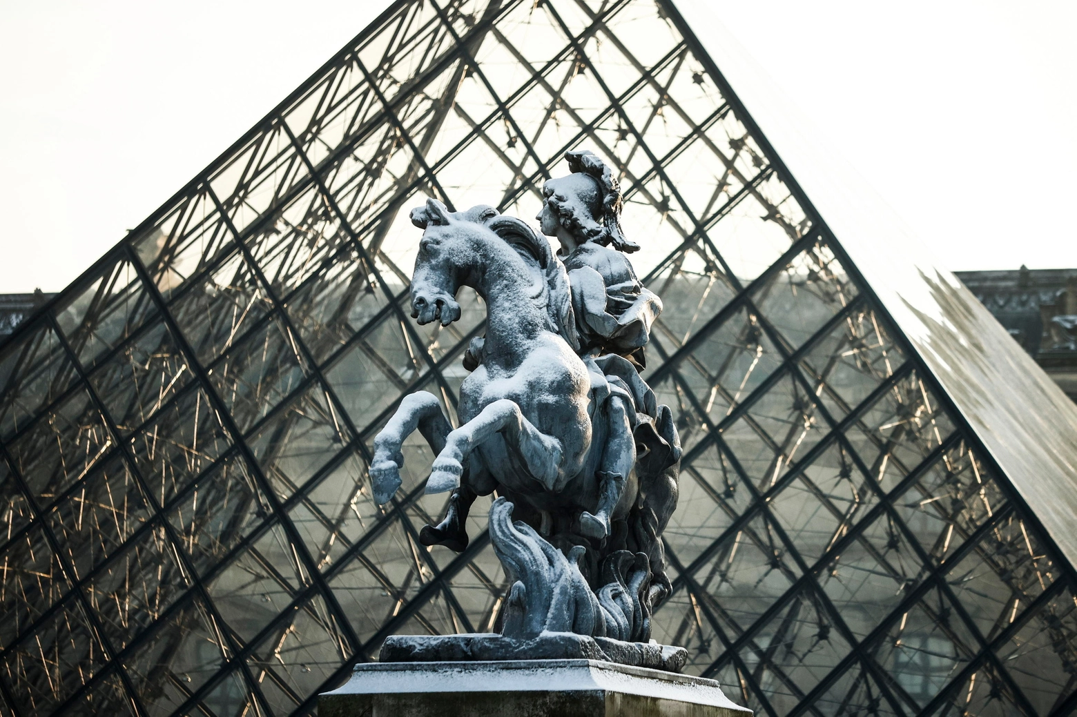 La statua di Luigi XIV davanti alla Piramide del Louvre