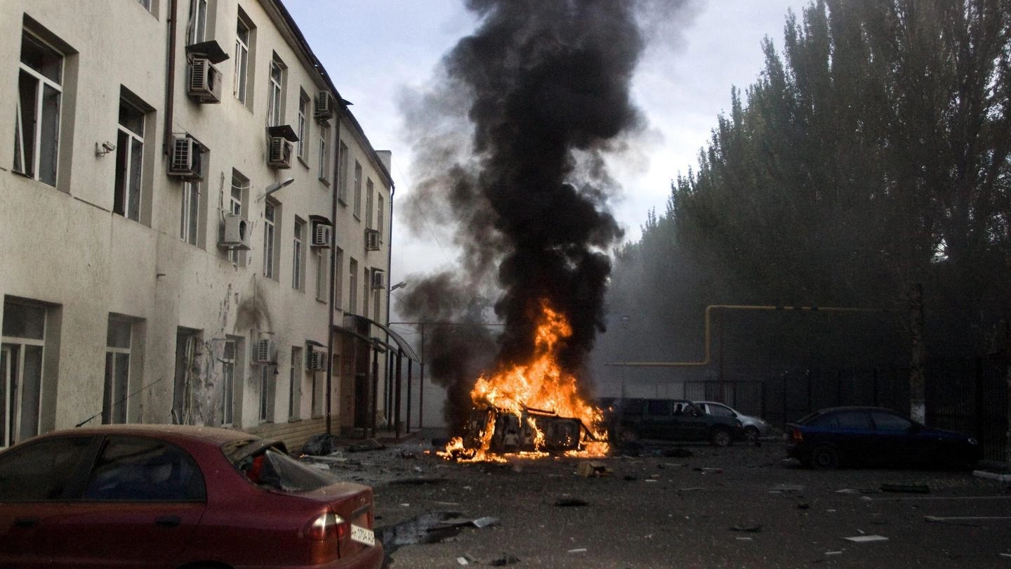 Un'auto in fiamme per un colpo di artiglieria a Donetsk (Ansa)