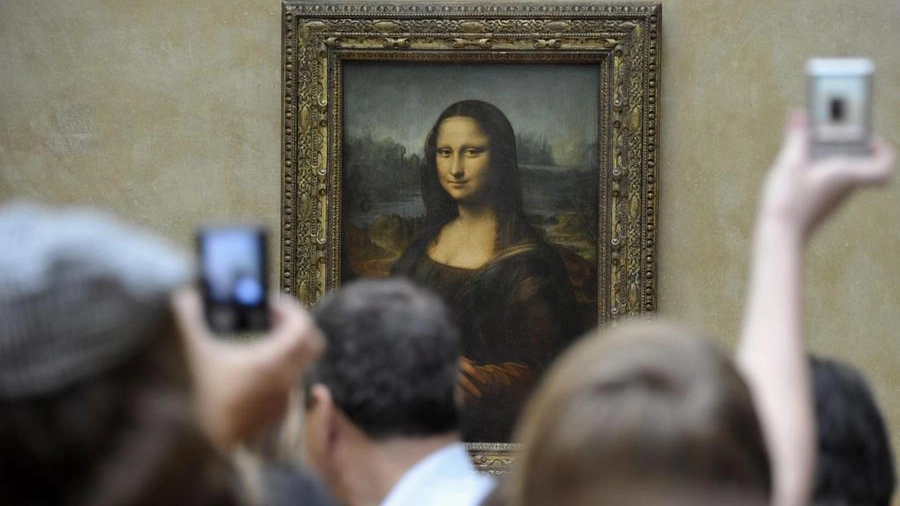Visitatori scattano foto-ricordo alla Gioconda al Louvre (Ansa)