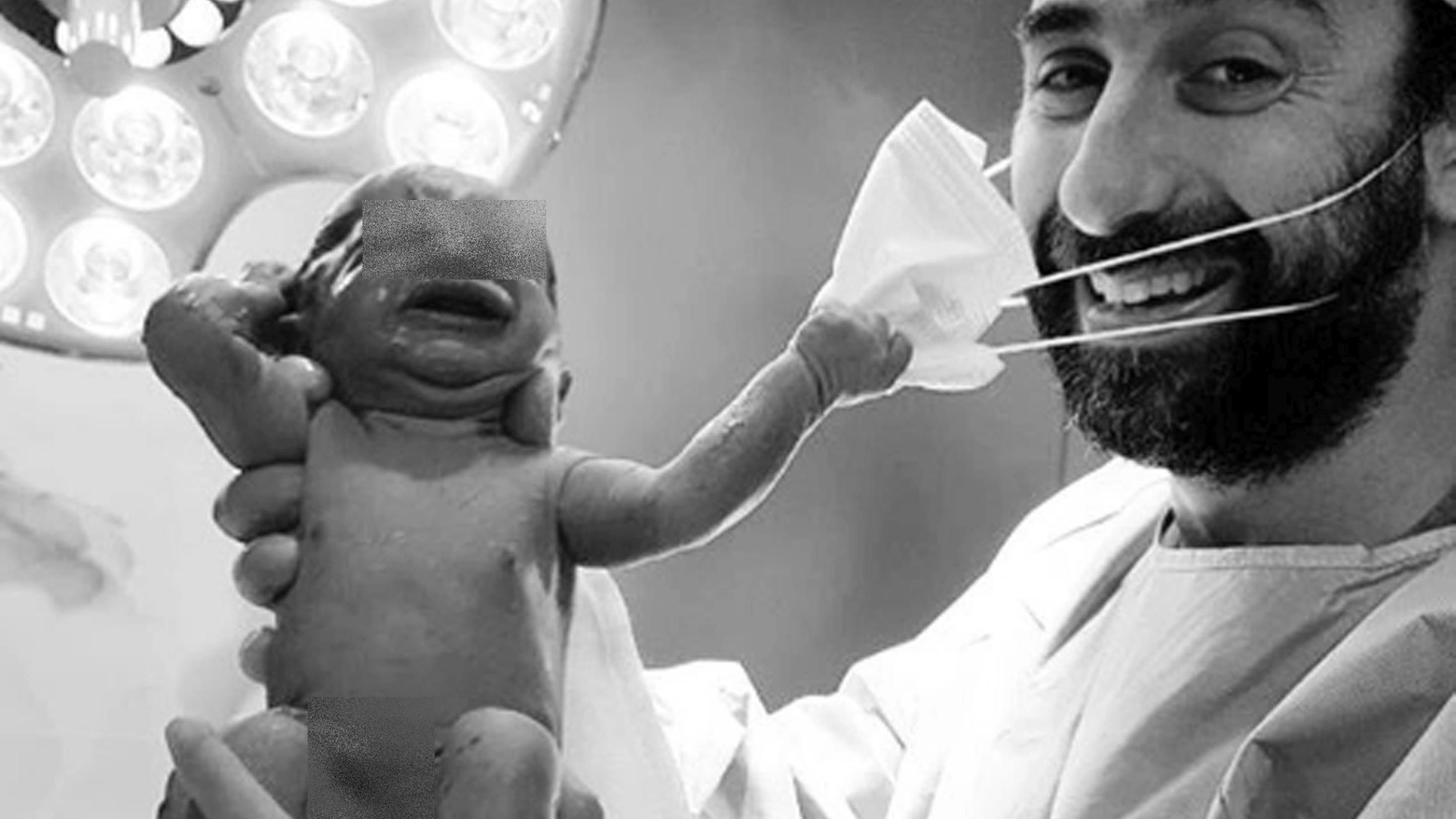 Il neonato strappa la mascherina dal volto del ginecologo: lo scatto di speranza (Ansa)