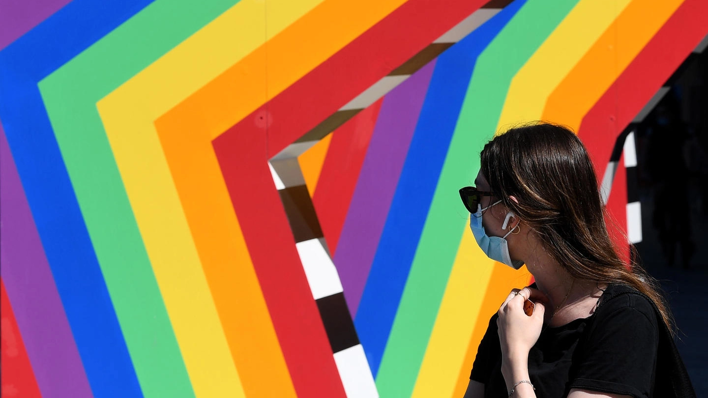 Una persona osserva un'installazione arcobaleno del Pride  (Ansa)