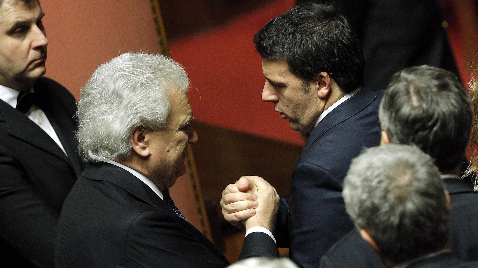 Il presidente del Consiglio Matteo Renzi stringe la mano a Denis Verdini in Senato (Ansa)