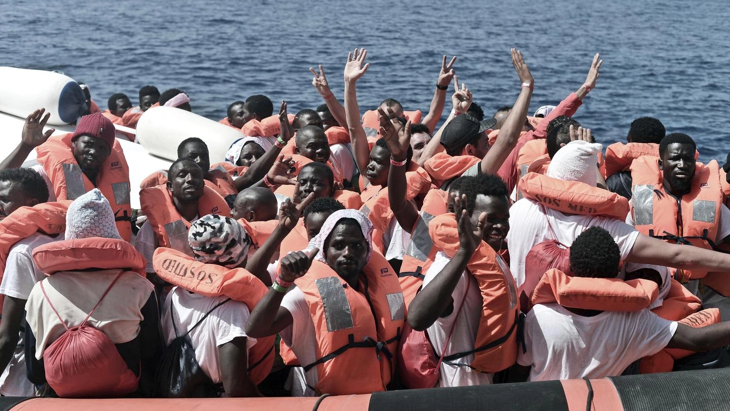 Aquarius, i migranti salutano durante il trasferimento alla nave della Guardia costiera