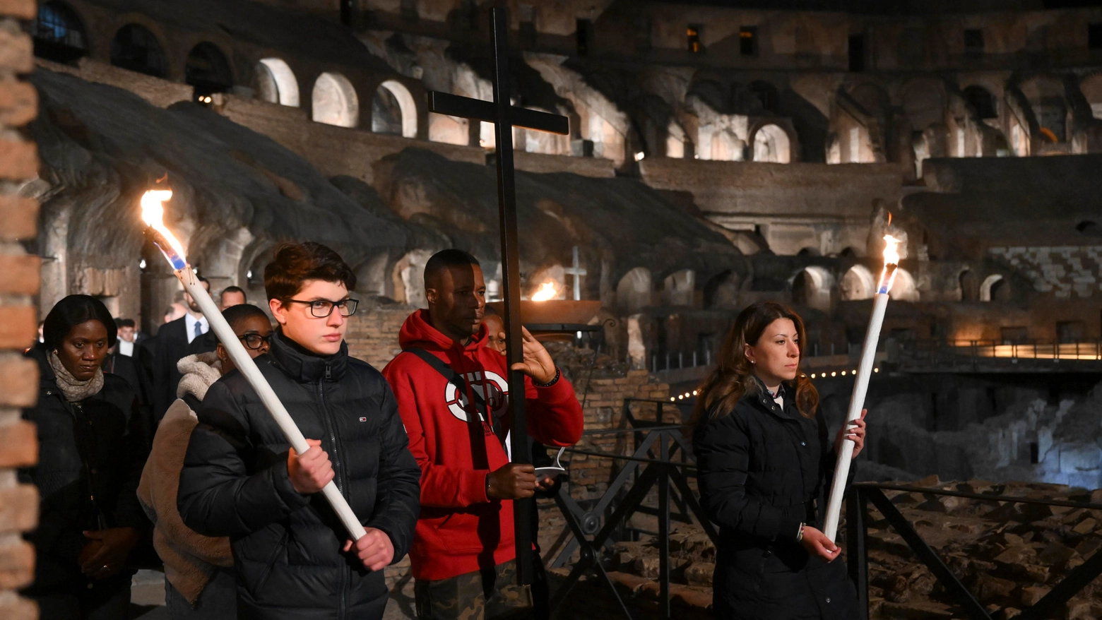 Il migrante porta la Croce nella Via Crucis al Colosseo