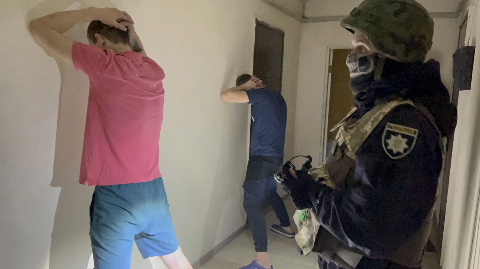 Due momenti dell'irruzione notturna degli agenti speciali in un palazzo di Kharkiv 