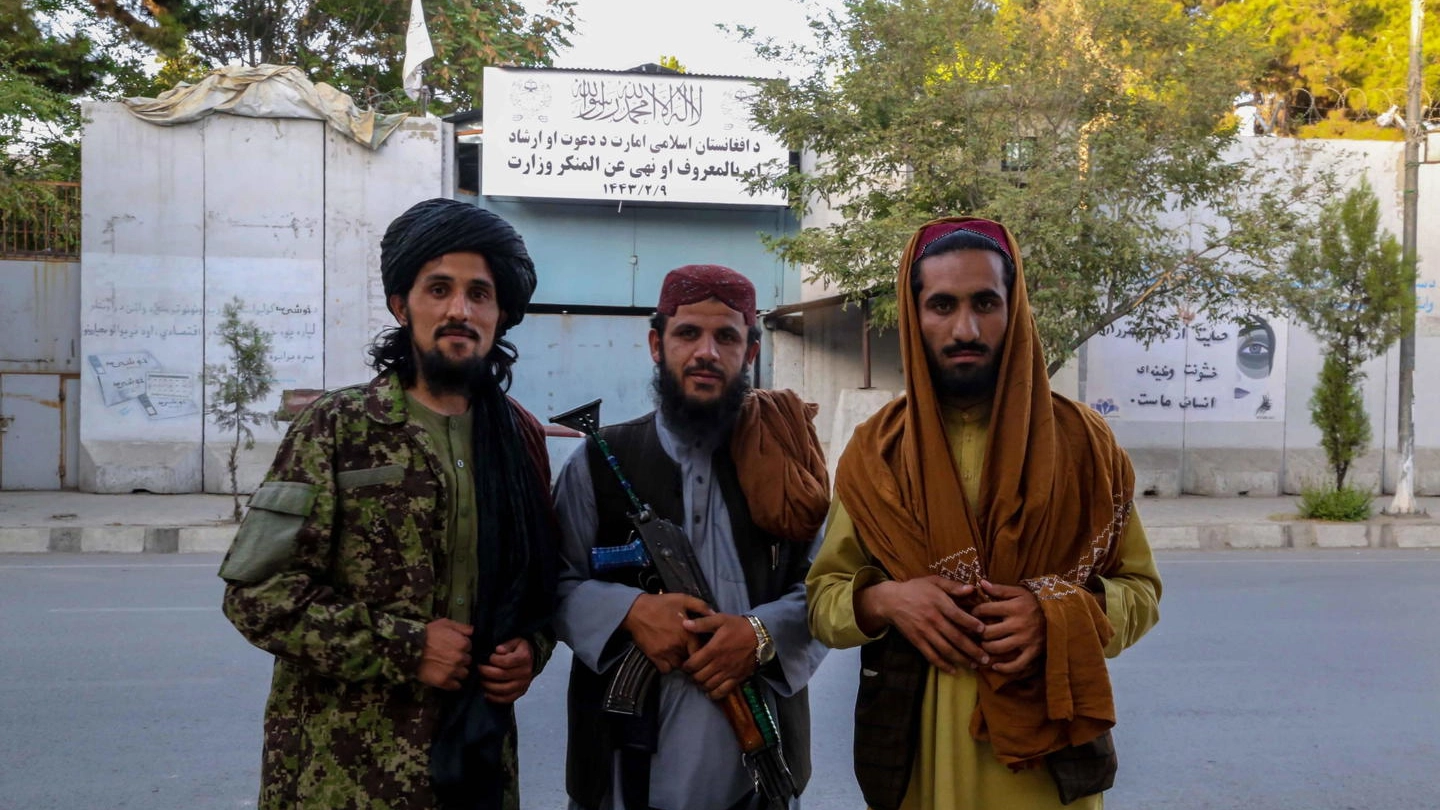 Tre uomini talebani davanti al ministero dei Vizi e dell Virtù afghano (Ansa)