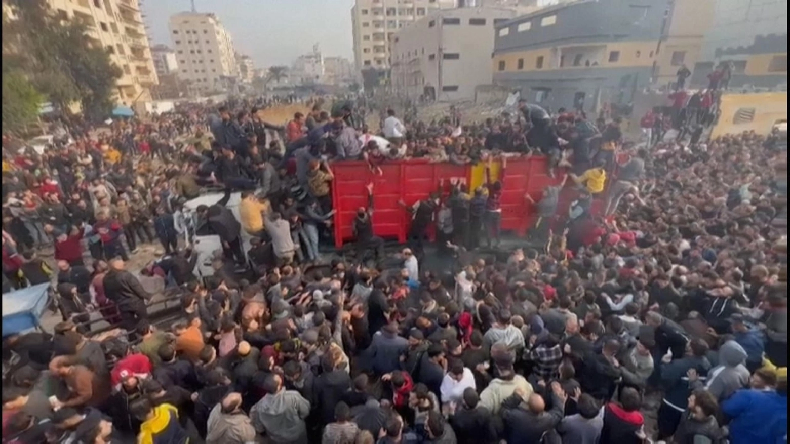 Il frame di un video che mostra centinaia di persone che assaltano camion aiuti a Gaza (Ansa)