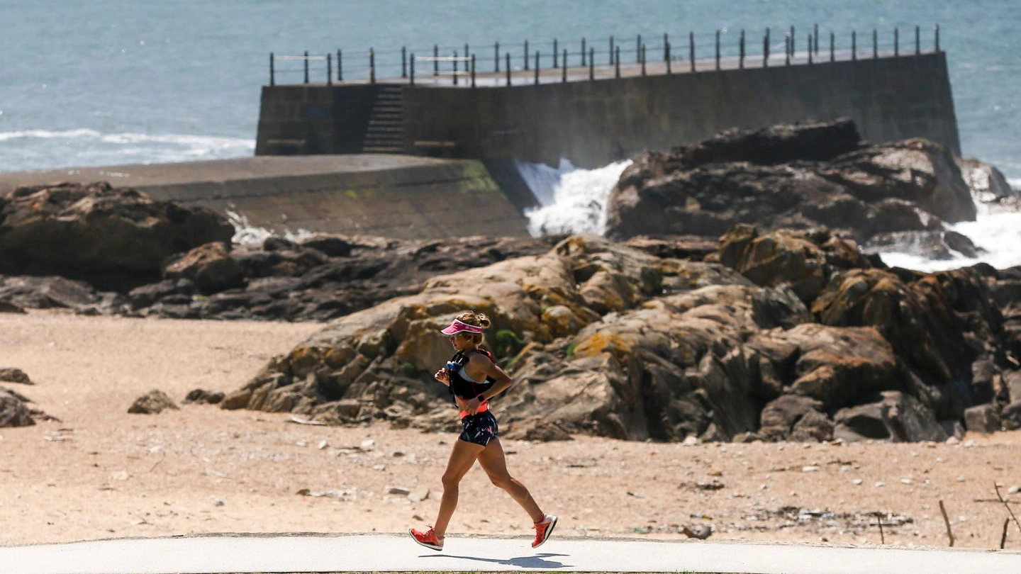 Una donna fa jogging vicino alla spiaggia (Ansa)