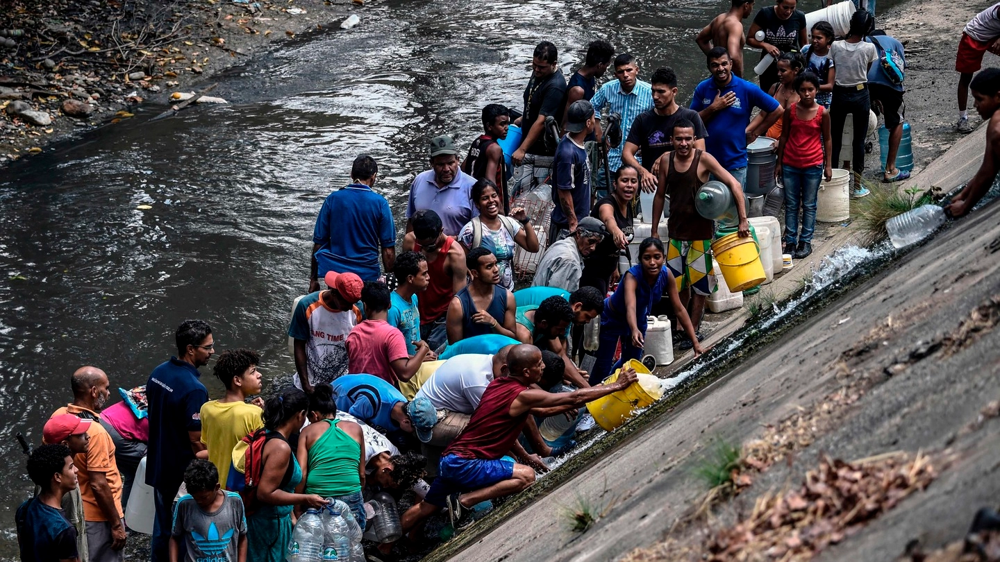 Caracas, reti idriche in tilt. La popolazione raccoglie acqua dai canali (Afp Ansa)
