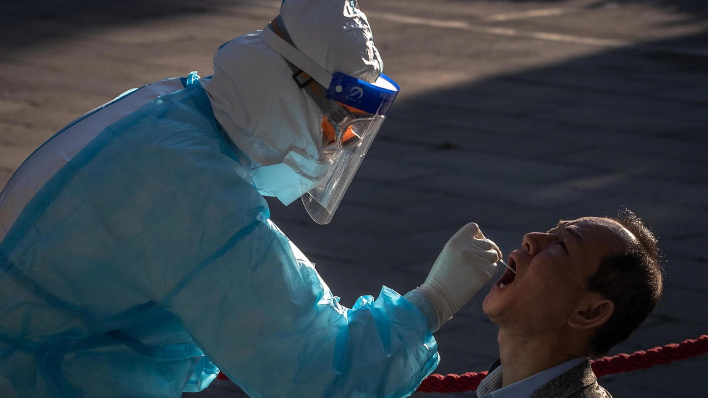 Un giornalista sottoposto a tampone per Coronavirus a Pechino (Ansa)