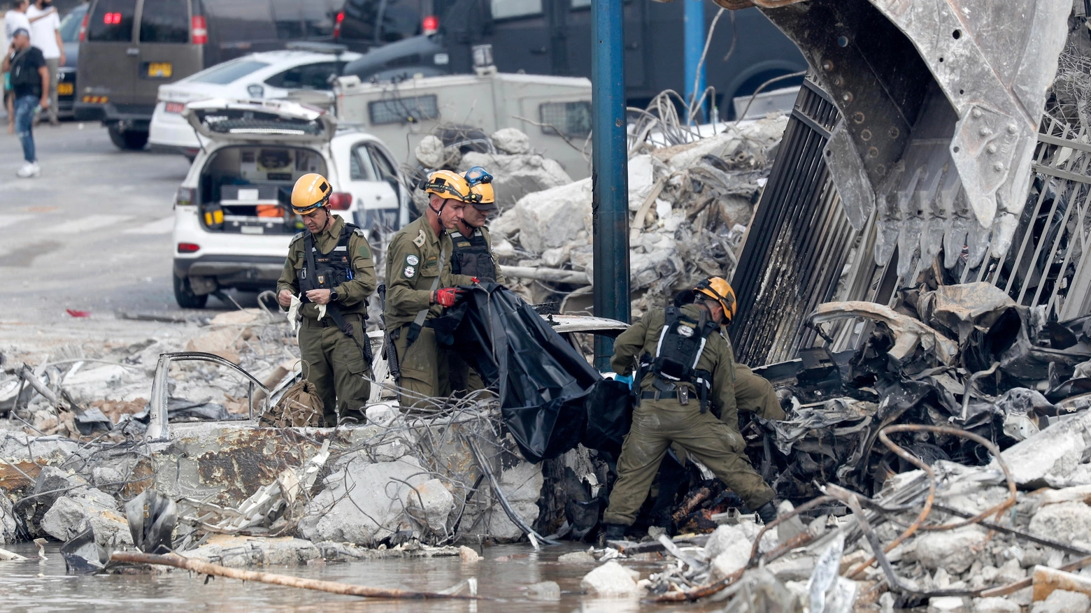 Soldati israeliani al lavoro tra le macerie di una stazione di polizia distrutta a Sderot (Ansa)