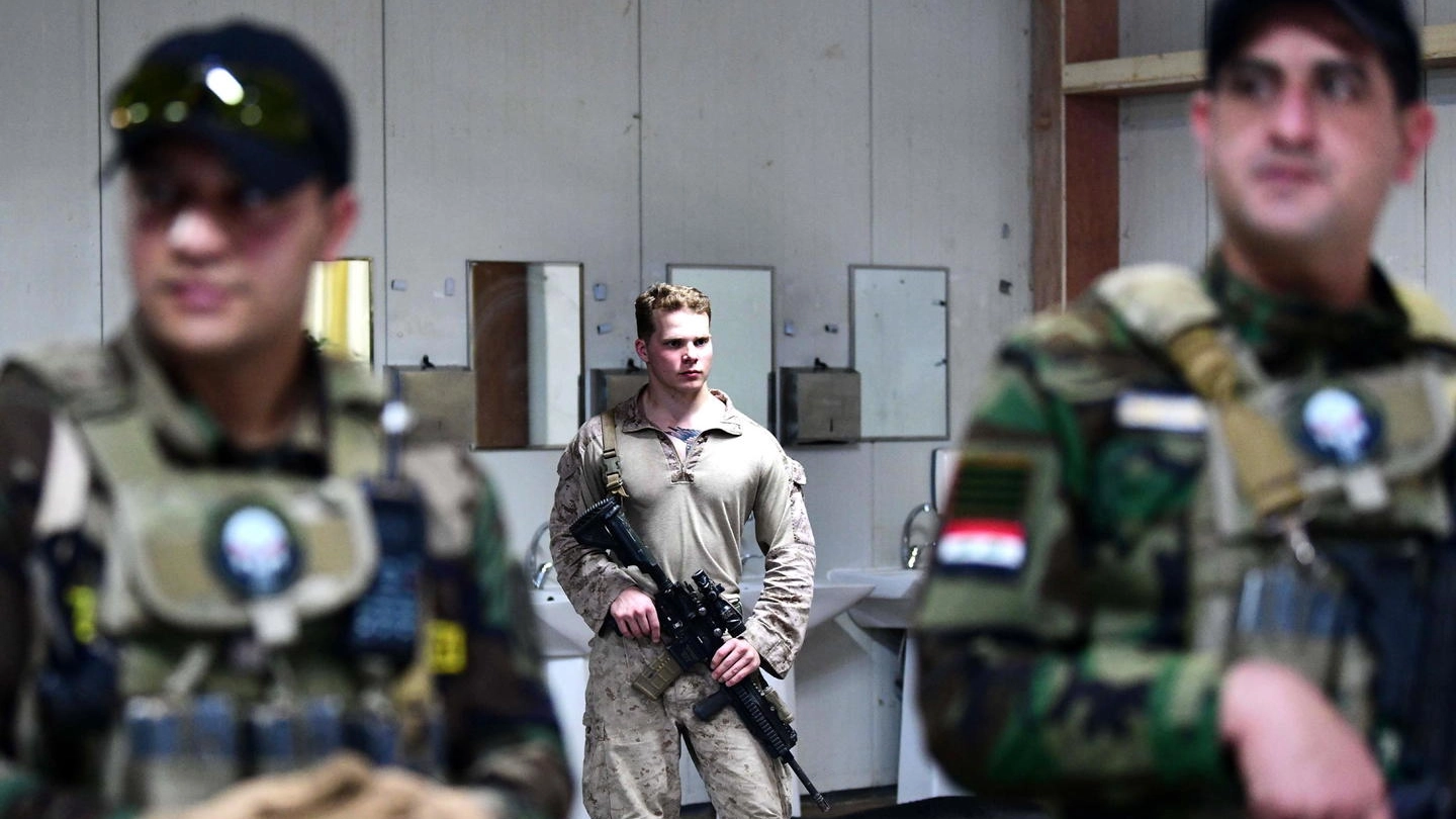 Un soldato Usa di guardia con due militari iracheni (Ansa)