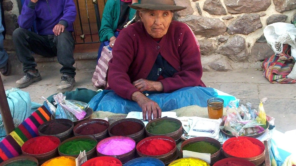 Una venditrice in un colorato mercato peruviano
