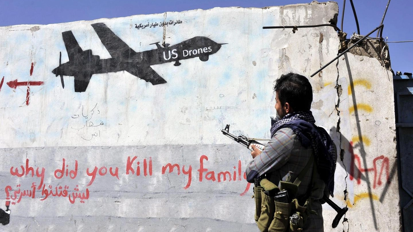Un miliziano sciita Huthi guarda un murales che rappresenta un drone Usa (Ansa)