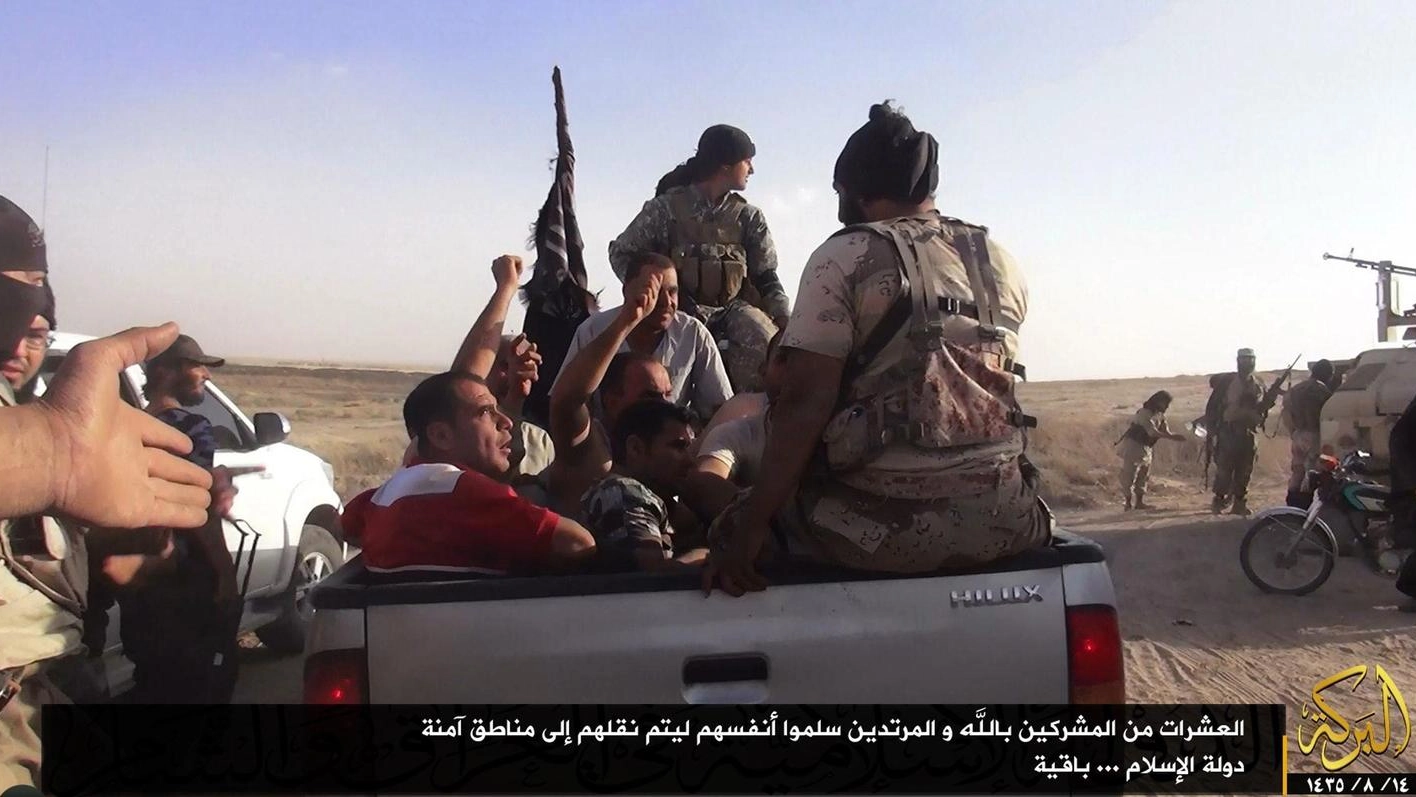 Dei miliziani dell'Isis con prigionieri iracheni (Ansa)
