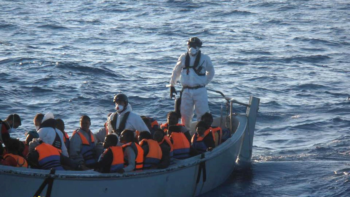 La Marina militare soccorre migranti su barconi nell'operazione Mare Nostrum (Ansa)