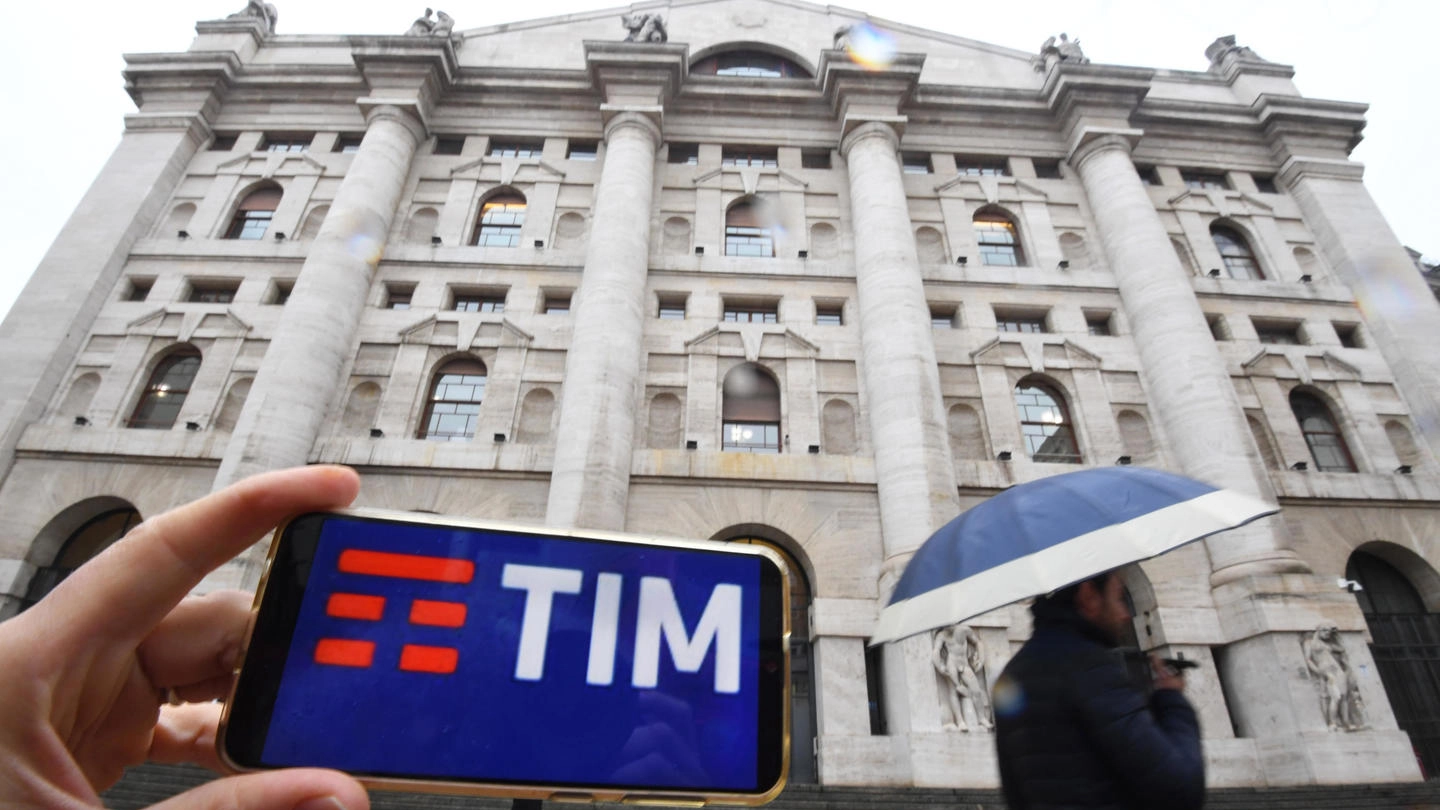 Il logo di Tim è visibile sullo schermo di una smartphone in piazza Affari