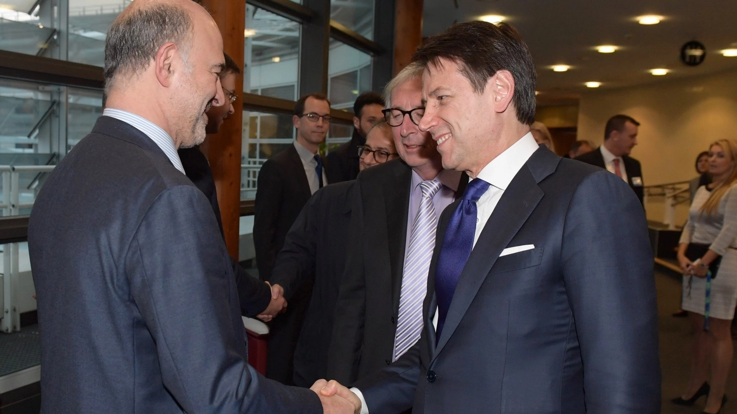 Stretta di mano tra Moscovici e Conte alla presenza di Junchker (ImagoE)