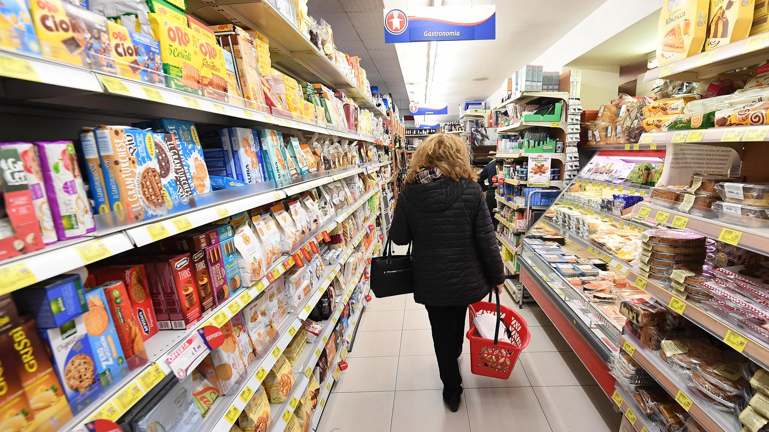 Una donna fa la spesa in un supermercato (Ansa)