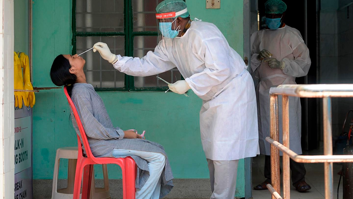 Un medico esegue un tampone per il Covid-19 in India (Ansa)