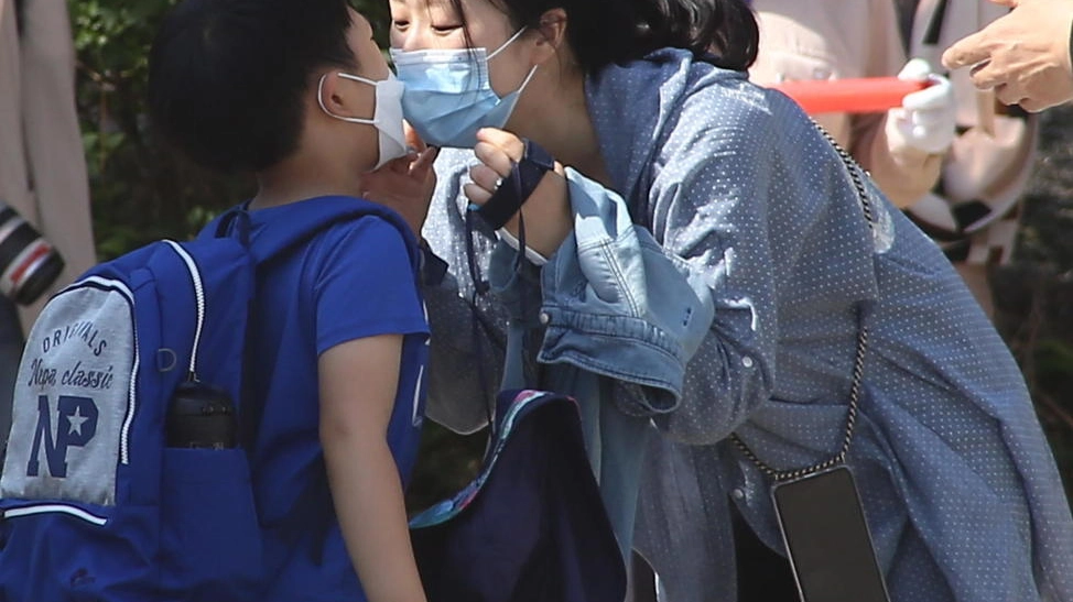 Seoul, bacio davanti a scuola con la mascherina (Ansa)