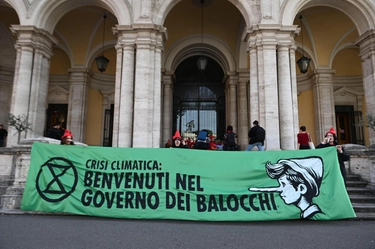 Crisi climatica, attivisti di Extinction Rebellion vestiti da Pinocchio bloccano il ministero dei Trasporti: “Benvenuti nel Governo dei Balocchi”