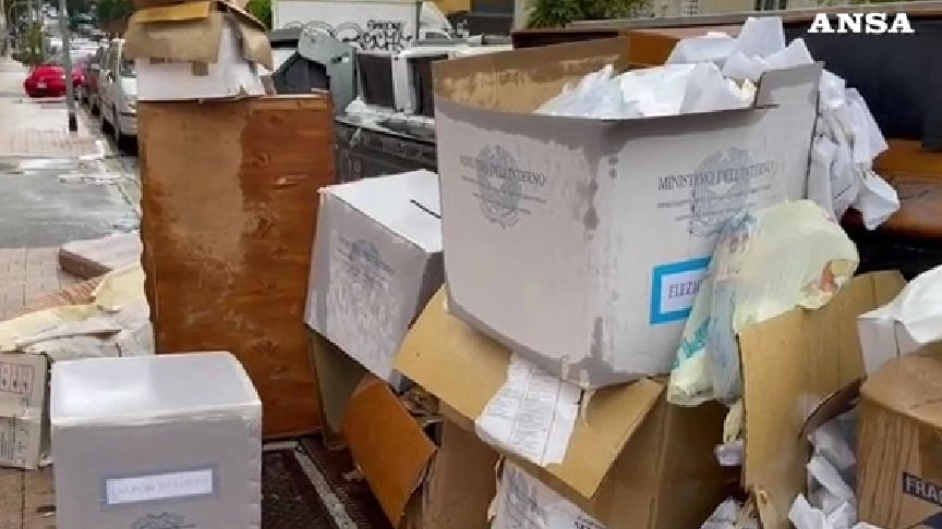 Urne elettorali abbandonate tra cumuli di rifiuti in strada