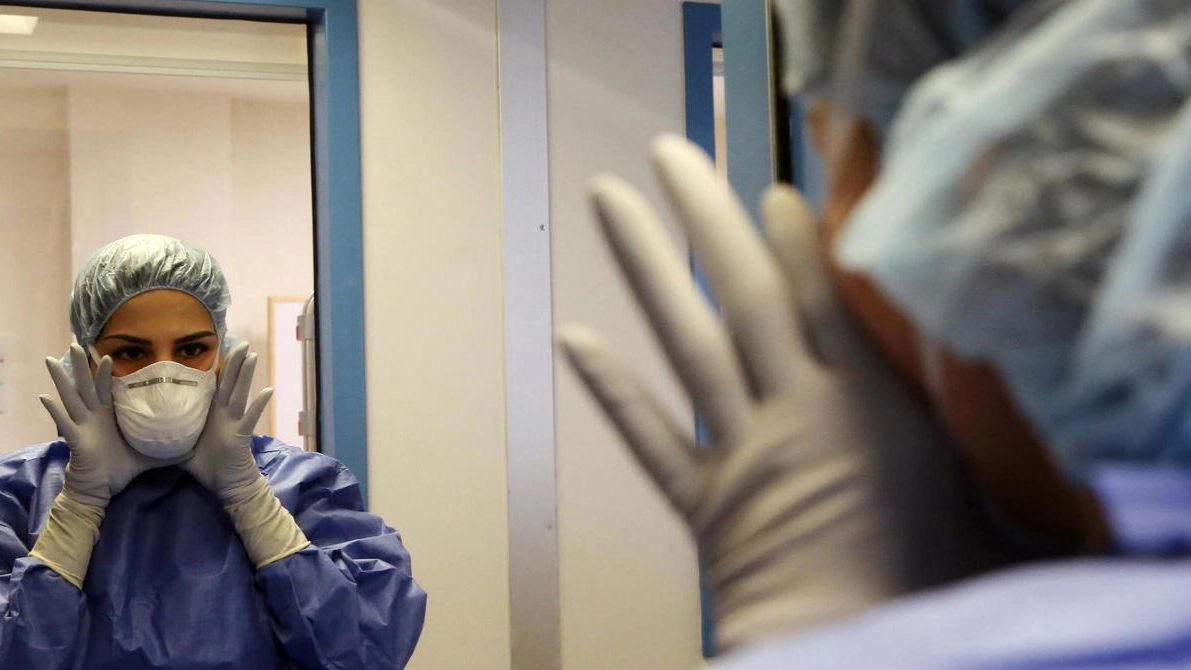 Due medici si parlano attraverso il vetro in un reparto Covid
