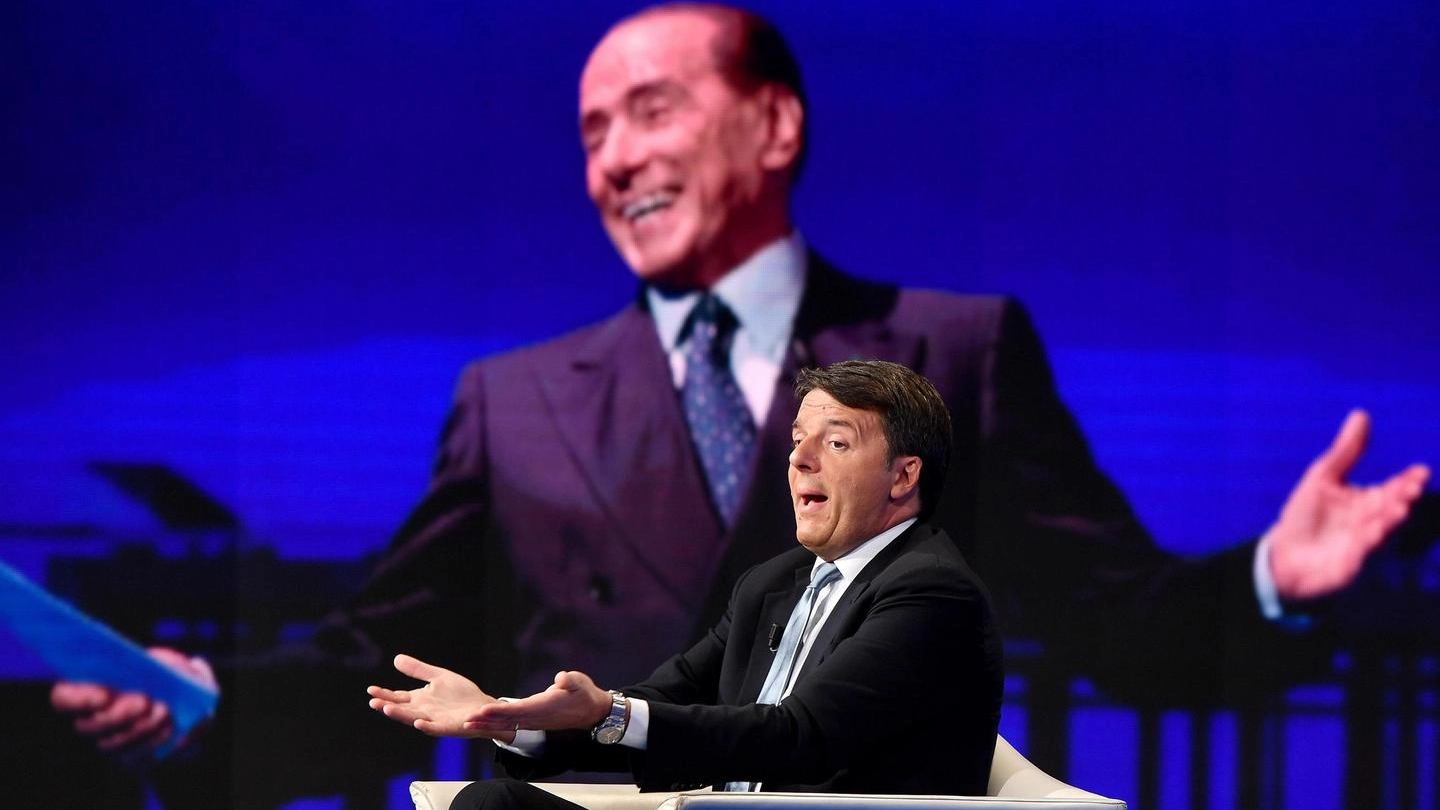 Il segretario Pd Matteo Renzi, sullo sfondo un'immagine di Silvio Berlusconi (Ansa)