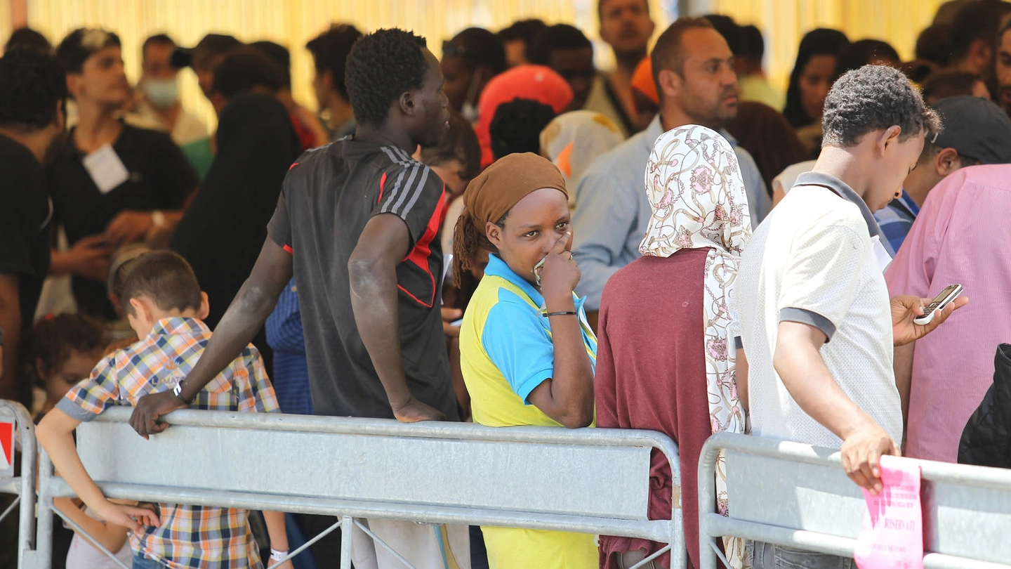 Immigrati in fila per i controlli sanitari e l'identificazione (lapresse)