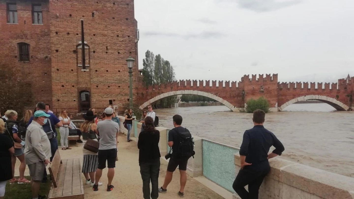 Curiosi a Verona aspettano il passaggio della piena dell'Adige (Ansa)