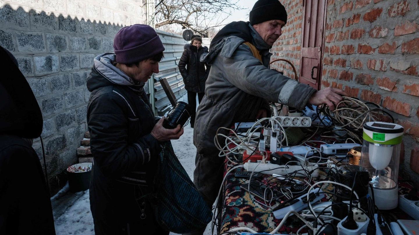 Ucraini ricaricano batterie e telefoni cellulari nella città di Siversk (Ansa)