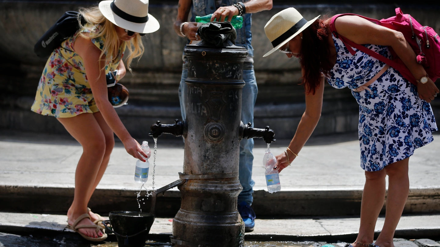 Due turiste attingono acqua da una fontana (Lapresse)